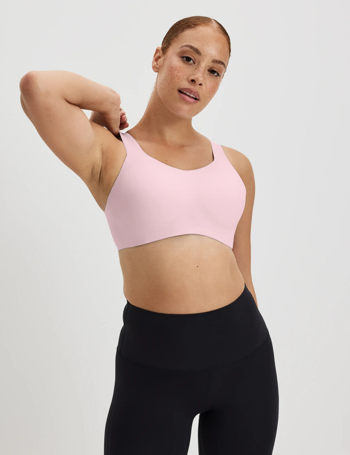 Adecia is a 34D wearing KNIX M+ | Full-body view of model wearing the Catalyst Sports Bra, highlighting the neckline, strap design, and smooth silhouette | Pink Party