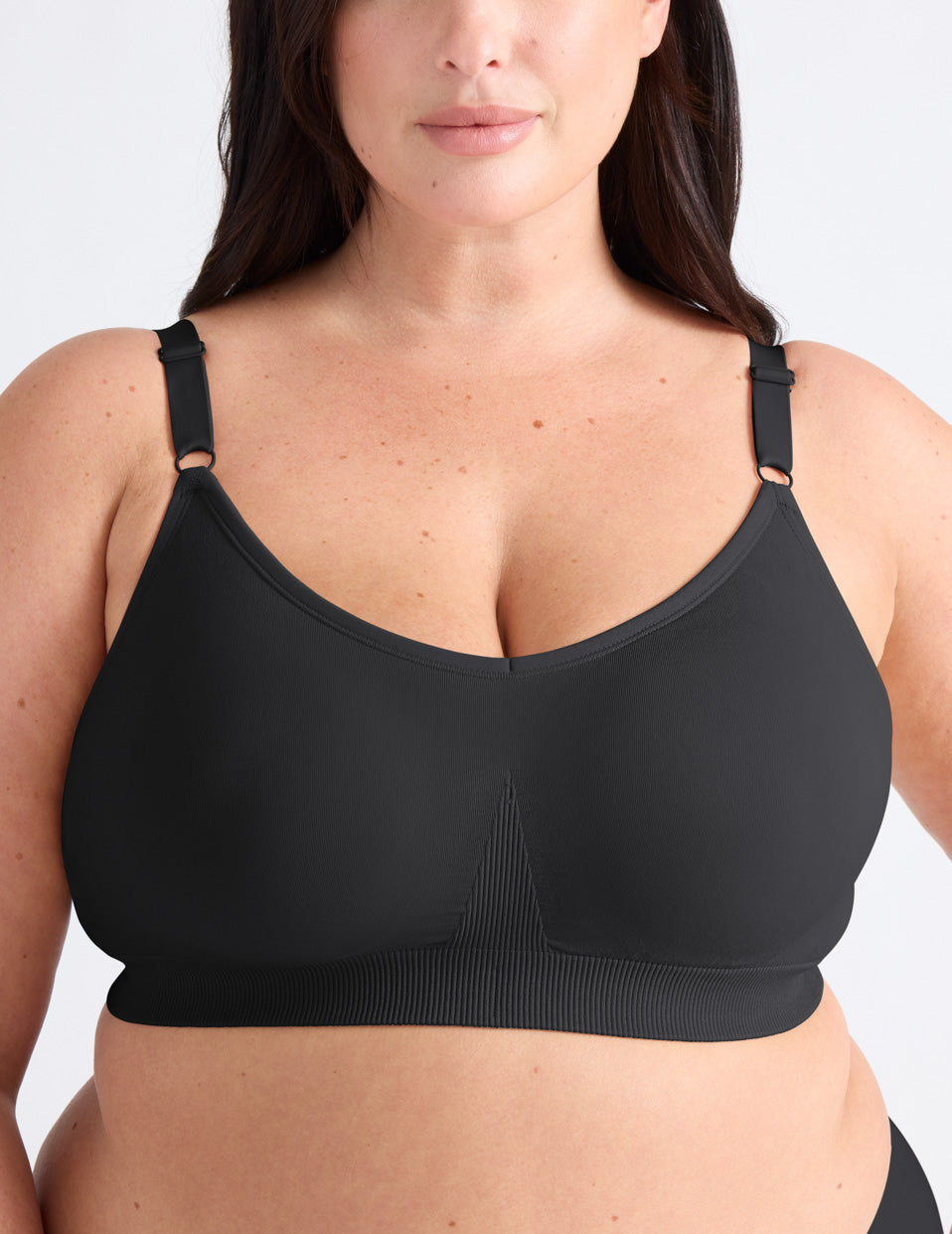 Gabrielle is a 38E and wearing KNIX XL+ | Front view of model wearing the Good to Go Seamless Bra, highlighting the neckline, strap design, and  silhouette | Black