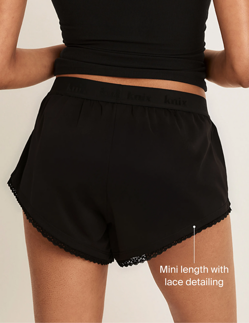 Back view of model wearing the Super Leakproof® Mini Dream Boxer highlighting the coverage and fit. On image text: Mini length with lace detailing
