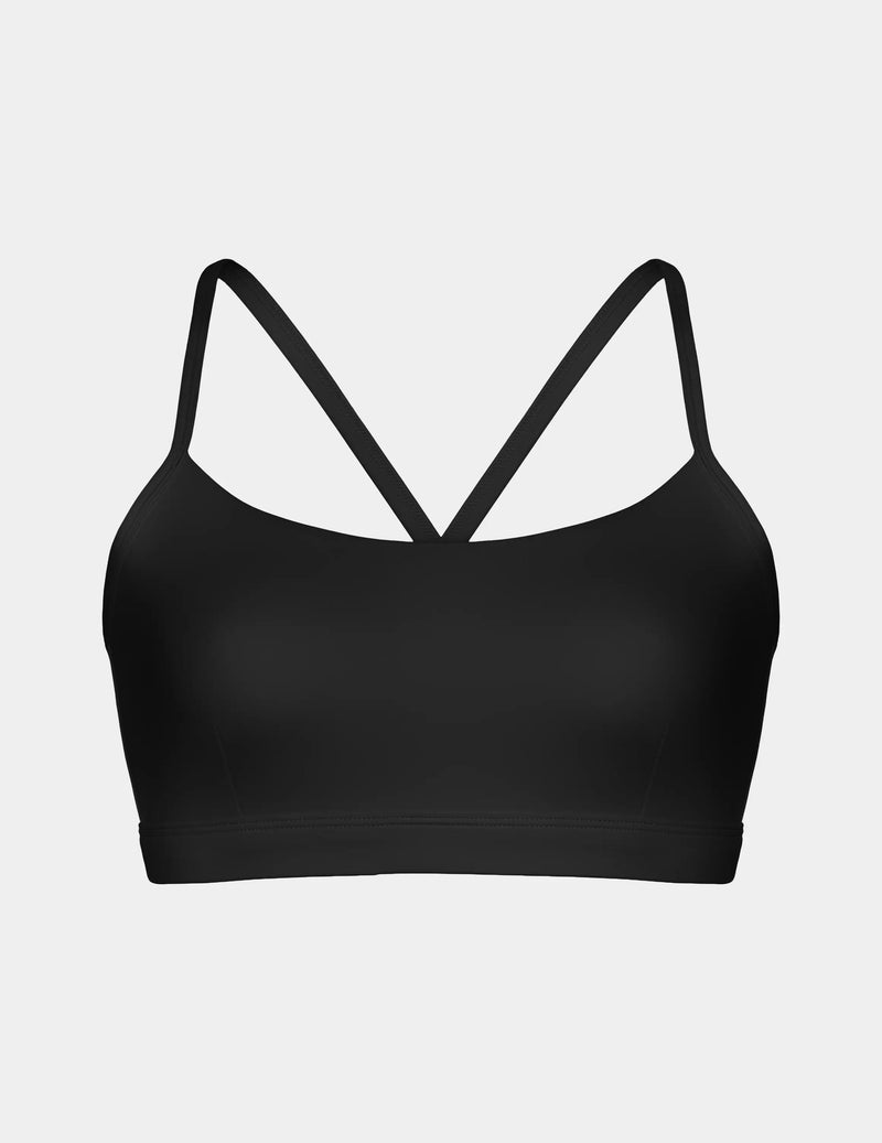 A black sports bra with thin crisscrossing straps at the back, shown against a light gray background.