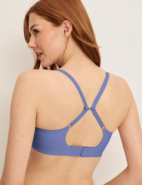 Back view of model wearing the Revolution Scoop Bra, highlighting the neckline, strap design, and smooth silhouette