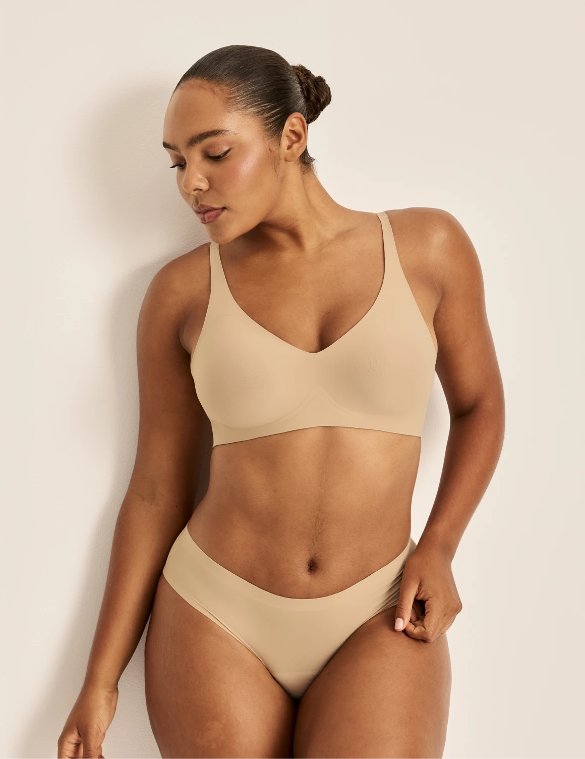Amber is a 36C and wearing KNIX L | Front view of model wearing the Revolution V-Neck Bra, highlighting the neckline, strap design, and smooth silhouette | Warm Sand