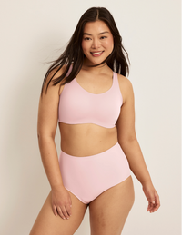 Front view of model wearing the Revolution Adjustable Pullover Bra, highlighting the neckline, strap design, and  silhouette